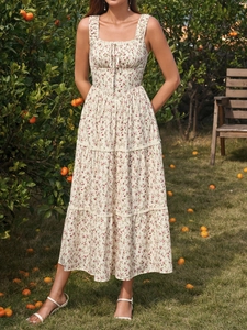 Detail of French floral dress with square neckline and tiered skirt in a sunny orchard