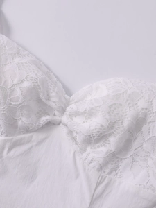 Détail du patchwork en dentelle blanche sur une robe courte dos nu moulante