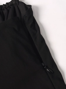 Close-up of black A-line dress waist with elastic pleats and hidden side zipper