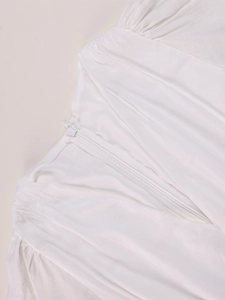 Detail view of white dress with invisible zipper and elegant pleated fabric texture