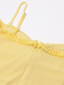 Detail of lemon yellow mesh dress with ruffled edges, straps, and hidden zipper