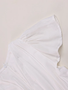 Detailed macro shot of white flutter sleeve dress fabric with subtle texture and invisible zipper