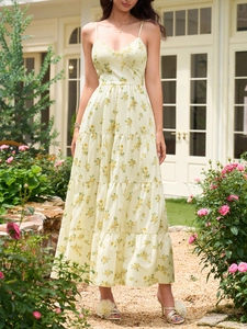 Détail d'une robe maxi jaune à fleurs avec décolleté en V et jupe à plusieurs niveaux