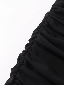 Détail du tissu en maille noire élégante avec un travail raffiné de fronces latérales