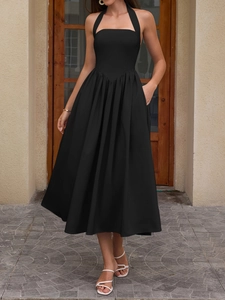 Detail of a black halter midi dress showing high-waist cut and functional side pockets