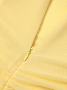 Detail of an invisible zipper on a bright lemon yellow mesh dress with fine fabric texture