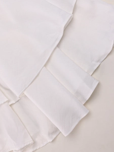 Close-up detail of layered ruffles and textured white fabric on an elegant mini dress