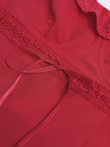 Detailansicht der roten Broderie-Anglaise-Spitze und der passenden Schleife aus Satin