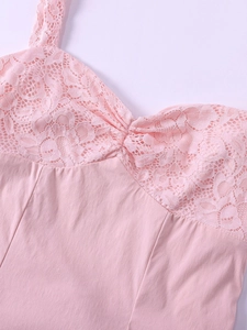 Détail de patchwork en dentelle rose et design froncé sur une robe courte ajustée