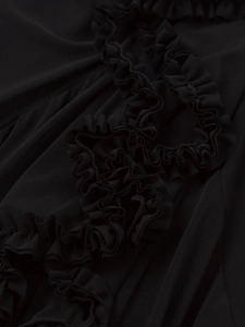 Detailed close-up of ruffle mesh fabric and layered pleats on this black sexy dress