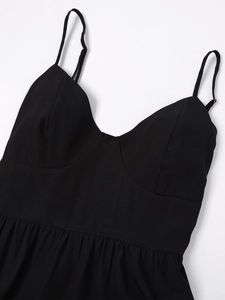 Détail du décolleté en V et des bretelles réglables de la robe longue noire à volants
