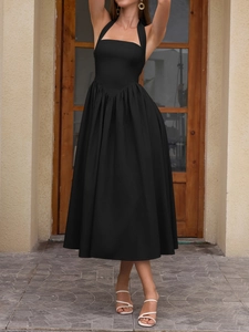 Detail of elegant black halter neck midi dress with a backless design and high waist cut