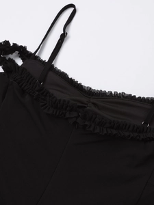 Close-up of adjustable straps and ruffle neckline detail on black mesh dress