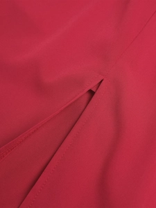 Detailansicht des Seitenschlitzes und der feinen Nähte am dunkelroten Stoffkleid