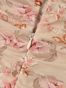 Macro shot of invisible zipper and pink floral mesh texture on a bodycon dress