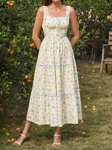 Detail of tiered floral maxi dress with blue lace trim and ruffled summer skirt layers