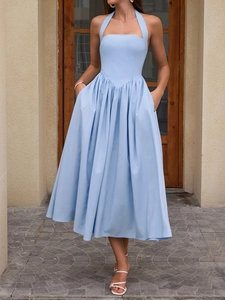 Detail of light blue halter neck dress featuring pleated skirt and functional side pockets