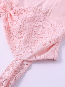 Gros plan sur la dentelle rose et les motifs floraux de cette robe d'été dos nu