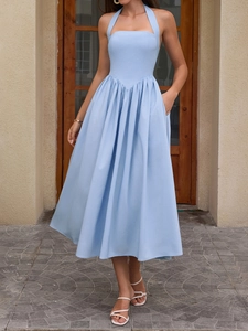 Detail view of light blue halter dress with V-shaped waist seam and functional side pockets