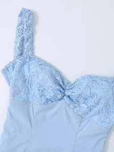 Détail de dentelle bleu clair avec design torsadé et texture florale sur la robe