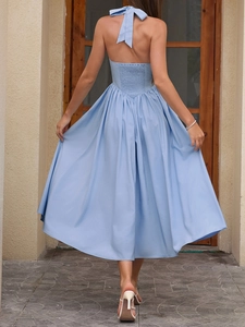 Back view of light blue halter dress featuring a large bow tie and open back design
