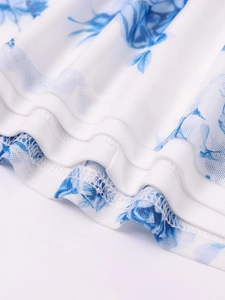 Detailed close-up of blue floral mesh fabric with professional hemmed edge and stitching