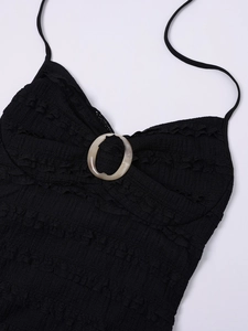 Close-up of black textured halter dress with decorative marble resin ring at the bust