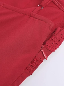 Details von verdecktem Reißverschluss und Trägern an rotem Kleid mit Hohlstickerei-Spitze