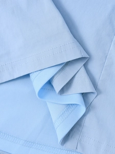 Vue macro du tissu en maille bleu clair montrant la texture fine et la double couture