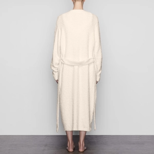 Back view of a long cream plush bathrobe with a belted waist and soft teddy fleece texture