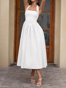 Detailed view of the V-shaped waist pleats and halter neck design on a white midi dress
