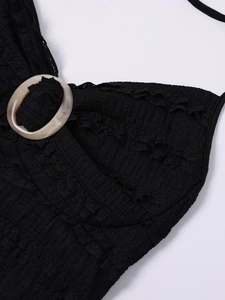 Close-up of black ribbed texture fabric and marble resin ring detail on halter dress