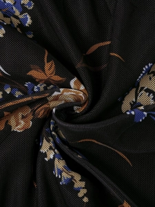 Close-up of semi-transparent black mesh fabric with vintage floral print detail