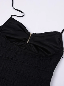 Detail of black halter dress showing textured pleats and side invisible zipper closure