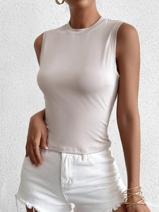 Détail d'un débardeur beige ajusté sans manches avec short en jean blanc d'été
