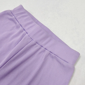 Dettaglio ravvicinato della vita alta elastica e del tessuto a coste viola degli shorts