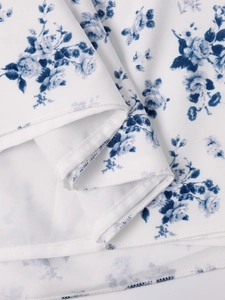 Vue macro détaillée de l'imprimé floral bleu sur un tissu tissé blanc de qualité