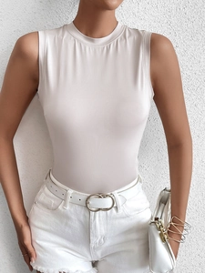 Détail du haut court sans manches beige coupe slim avec short en jean blanc et ceinture