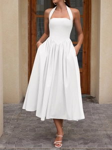 Detail of white halter neck dress with basque waistline and pleated voluminous skirt