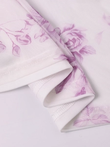 Close-up of white mesh fabric with purple rose print and fine overlock stitching details