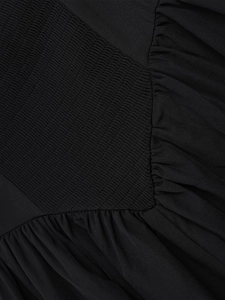 Nahaufnahme von schwarzem Stoff mit Smok- und Kräuseldetails für ein tailliertes Kleid
