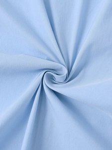 Détail du tissu bleu clair montrant la texture fine et le drapé doux de la robe courte