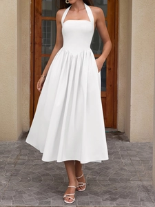 White halter midi dress with a backless design and practical side pockets in elegant style