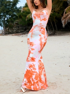 Detail of slim-fit backless maxi dress with orange marble print on a sunny beach