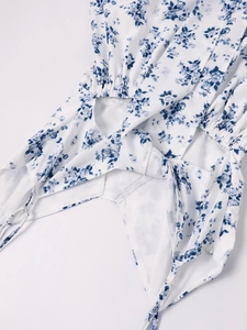 Détail d'une robe à fleurs col en V avec découpe à la taille et bretelles lacées
