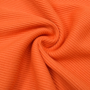 Detailed close-up showing the ribbed texture and vibrant orange fabric of the jumpsuit
