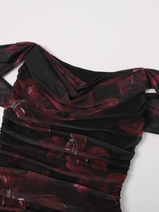 Detail of black mesh dress featuring deep red floral print and ruched fabric texture