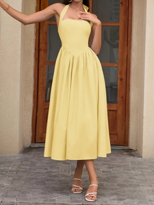 Detail of light yellow halter dress with V-shaped waist and pleated skirt for summer vacation
