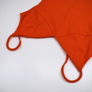 Close-up of orange ribbed fabric texture and stitching details on thin straps
