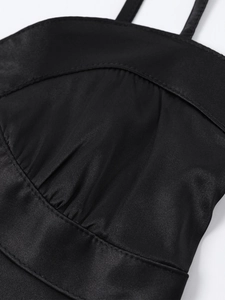 Detailed view of black satin dress featuring pleated bust design and thin shoulder straps